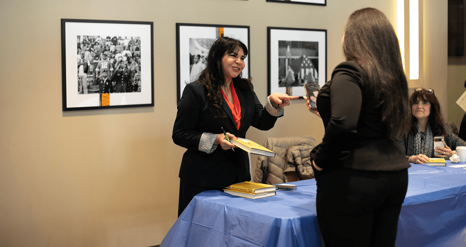 A business owner talking with guests at a community reception